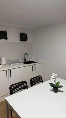 a kitchen with a table and two chairs and a sink at Rua Nova in Sarria