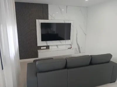 a living room with a couch and a flat screen tv at Alojamiento FCB Rúa Nova in O Pedrouzo