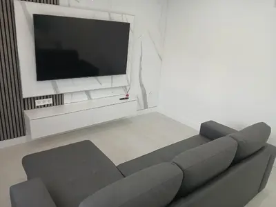 a living room with a couch and a flat screen tv at Alojamiento FCB Rúa Nova in O Pedrouzo