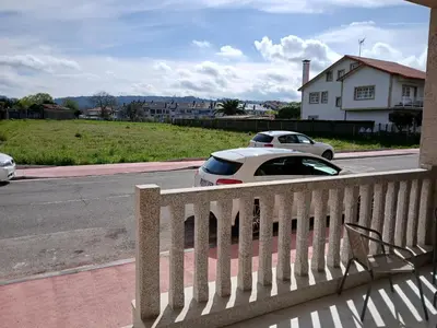 a white car parked on the side of a street at Alojamiento FCB Rúa Nova in O Pedrouzo
