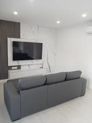 a living room with a couch and a flat screen tv at Alojamiento FCB Rúa Nova in O Pedrouzo