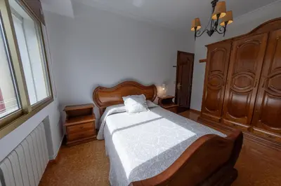 a bedroom with a large bed with a wooden headboard at Duplex en Burela Mi Piso 90 in Burela de Cabo