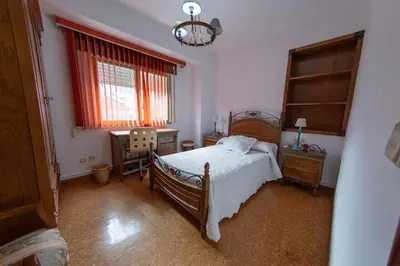 a bedroom with a bed and a desk and a window at Duplex en Burela Mi Piso 90 in Burela de Cabo