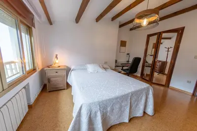 a bedroom with a bed and a desk and a window at Duplex en Burela Mi Piso 90 in Burela de Cabo