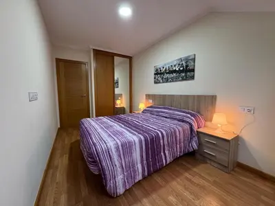 a bedroom with a large bed with a purple blanket at Apartamento en Barreiros in San Miguel de Reinante