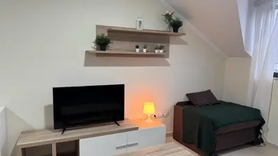 a living room with a flat screen tv and a chair at Apartamento en Barreiros in San Miguel de Reinante