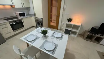 a white table and chairs in a kitchen at Apartamento en Barreiros in San Miguel de Reinante