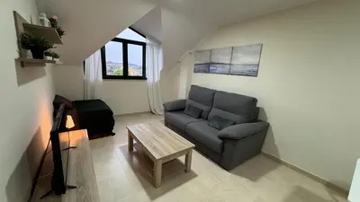a living room with a couch and a table at Apartamento en Barreiros in San Miguel de Reinante
