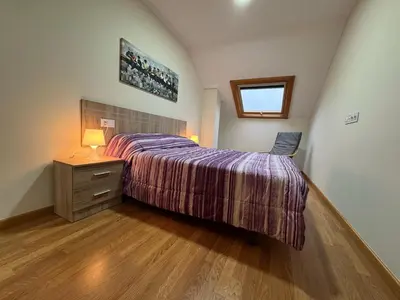 a bedroom with a bed and a dresser and a window at Apartamento en Barreiros in San Miguel de Reinante