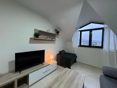 a living room with a flat screen tv and a window at Apartamento en Barreiros in San Miguel de Reinante