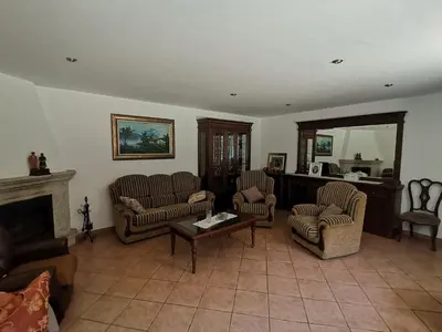 a living room with two chairs and a fireplace at Casa Brandelos in Bama