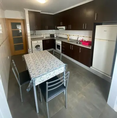 a kitchen with a table and chairs and a refrigerator at Terra 3A in Caldas de Reis