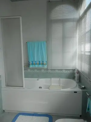 a white bathroom with a tub and a window at Villa Andrade in Mor