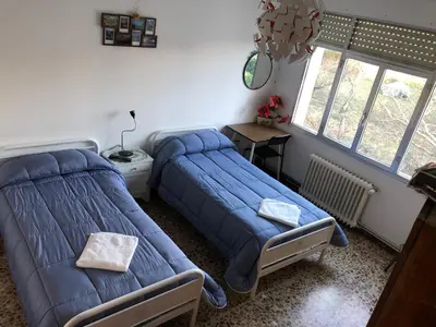 a bedroom with a bed and a table and a window at Hostal Costa Azul in Santiago de Compostela