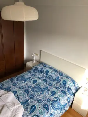 a bedroom with a bed with a blue and white comforter at Hostal Costa Azul in Santiago de Compostela