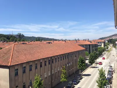 a large building with a red roof on a street at Hostal Costa Azul in Santiago de Compostela