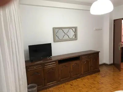 a living room with a flat screen tv on a wooden cabinet at Hostal Costa Azul in Santiago de Compostela