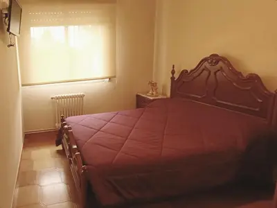 a bedroom with a bed with a red bedspread and a window at Pensión Prieto in Junquera de Espadañedo