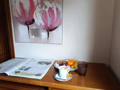 a table with a newspaper and a cup of coffee and fruit at Pensión Prieto in Junquera de Espadañedo