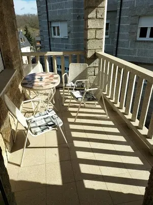 a patio with chairs and a table on a balcony at Casa familiar Sanabria in Ribadelago