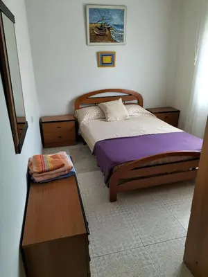 a bedroom with a bed and a table in it at Casa familiar Sanabria in Ribadelago