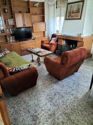 a living room with leather furniture and a fireplace at Casa familiar Sanabria in Ribadelago