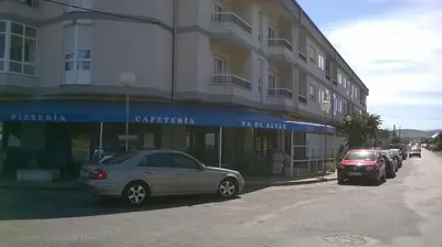 a car parked in front of a building at Zona Las Catedrales Barreiros Playa de Altar in Villadaíde