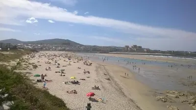 a large group of people on a beach at Zona Las Catedrales Barreiros Playa de Altar in Villadaíde