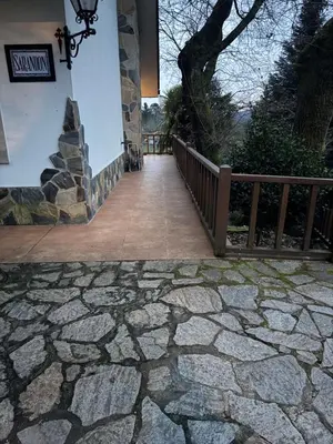 a stone walkway leading to a building with a fence at Casa Pepe Albela - 20 min de Santiago in Santiago de Compostela