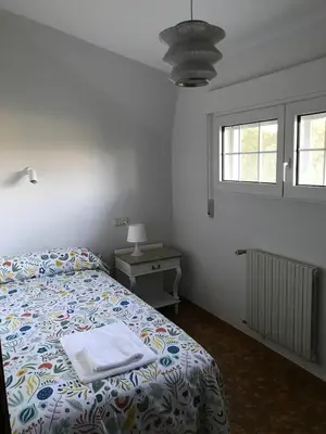 a bedroom with a bed and a table and a window at Casa Pepe Albela - 20 min de Santiago in Santiago de Compostela