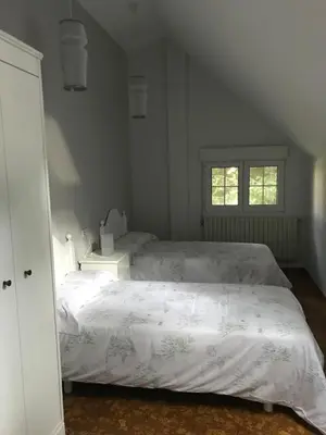 a bedroom with two beds and a window at Casa Pepe Albela - 20 min de Santiago in Santiago de Compostela