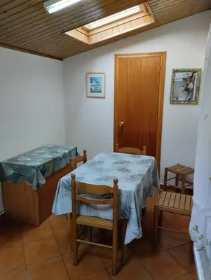 a room with a bed and a table and chairs at Casa María in Ribadeo