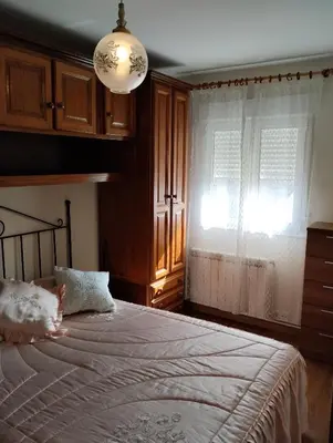 a bedroom with a large bed and a window at Casa María in Ribadeo