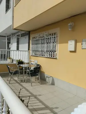 a patio with a table and chairs on a balcony at Casa María in Ribadeo