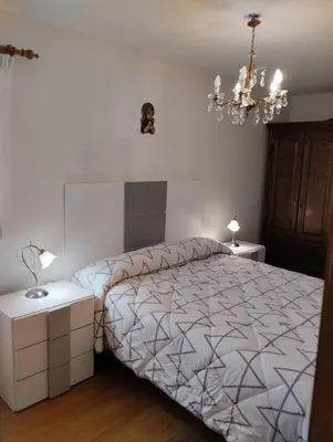 a bedroom with a large bed and a chandelier at Casa María in Ribadeo