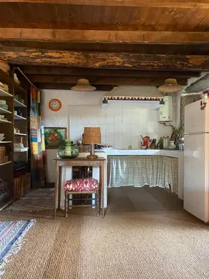 a kitchen with a table and a refrigerator at O Freixo in A Capela