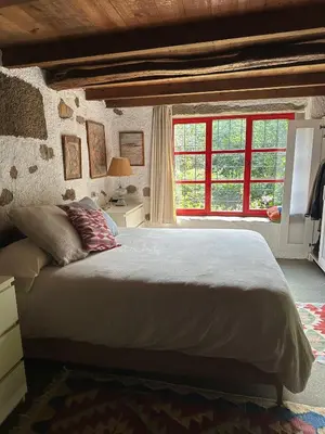 a bedroom with a large bed and a window at O Freixo in A Capela