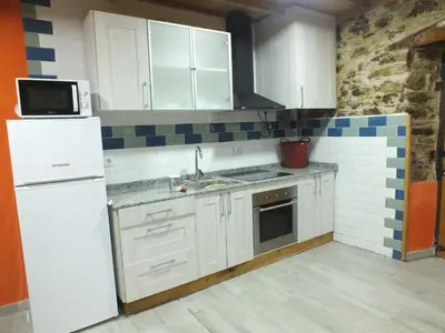 a kitchen with white cabinets and a white refrigerator at Apartamentos Rurales Casa Llucas in San Julián