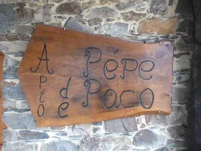 a sign on a stone wall that readsape pe pecca at Apartamentos Rurales Casa Llucas in San Julián