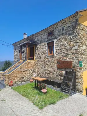 a stone building with a sign in front of it at Apartamentos Rurales Casa Llucas in San Julián
