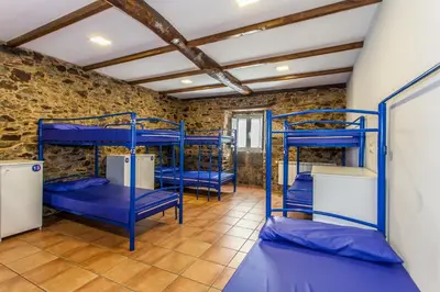 a room with blue bunk beds in it at Albergue Milpés in Ribadiso
