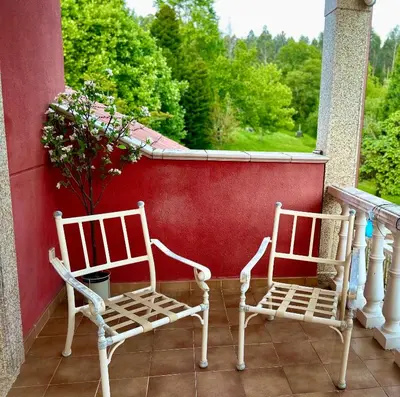 two chairs sitting on a porch with a window at Los Cedros in Cabañas