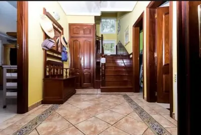 a hallway of a home with wooden doors and stairs at Los Cedros in Cabañas