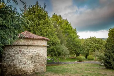 a stone wall with trees in the background at Cabaña familiar in Celanova