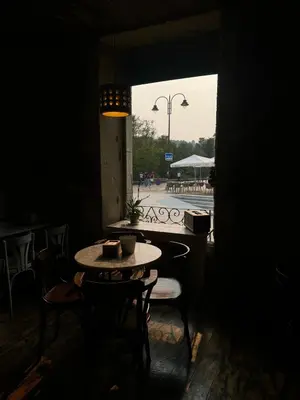 a table and chairs in a dark room with a window at Roots and Boots in Lugo