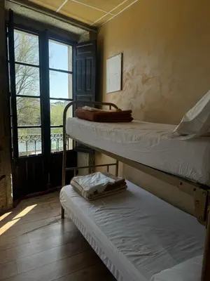 two bunk beds in a room with a window at Roots and Boots in Lugo