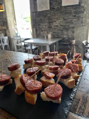 a bunch of pastries with pepperoni on them on a table at Roots and Boots in Lugo