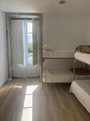 a room with three bunk beds and a window at Roots and Boots in Lugo