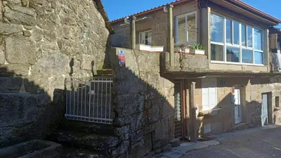 a stone building with a gate and a window at Casa Diaz in Cea