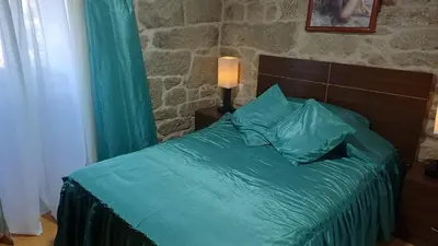 a bed with green sheets and pillows in a bedroom at Casa Diaz in Cea